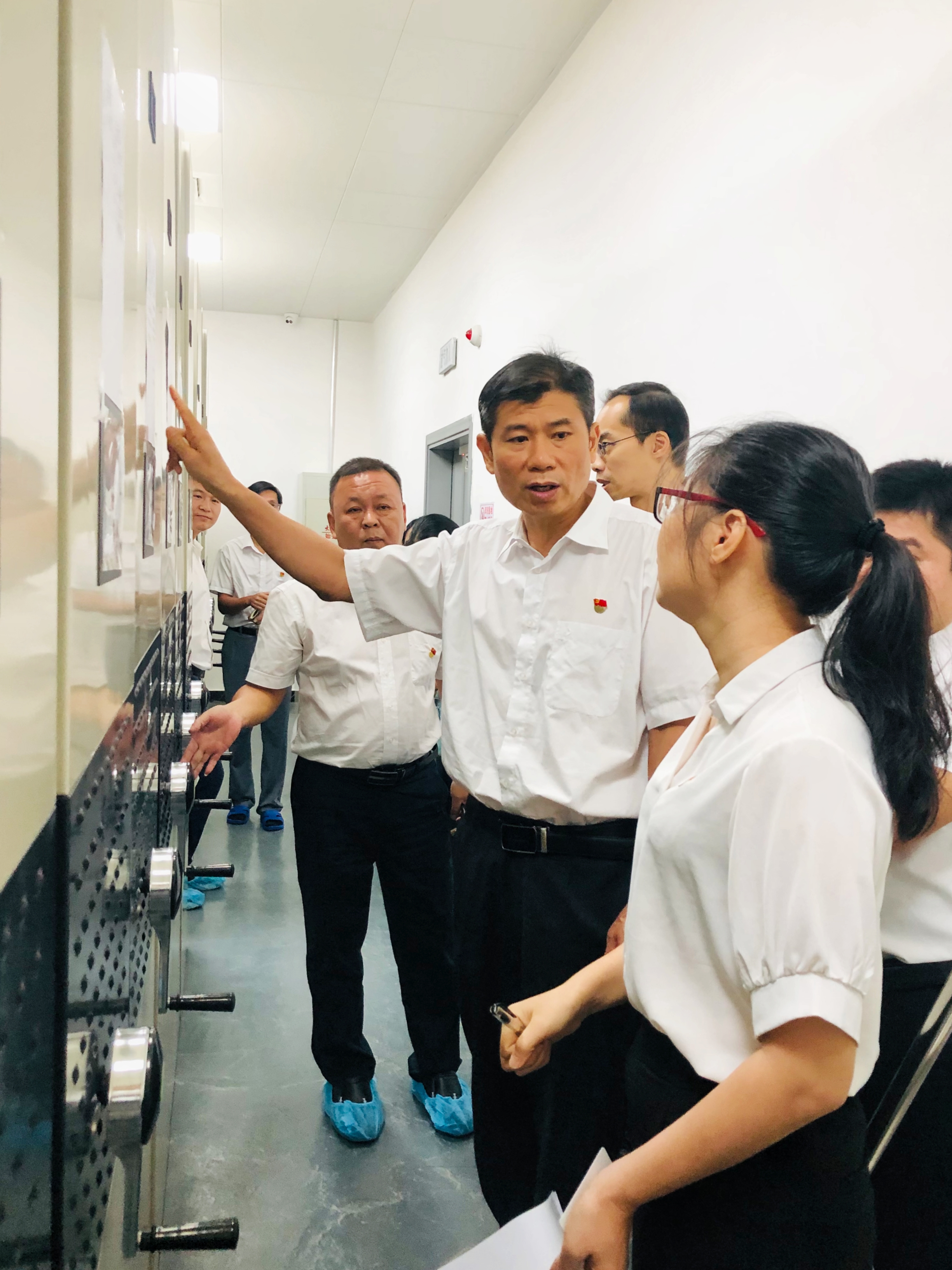 2021年9月 韶关市档案馆馆长申爱平(右四)到馆库房听取工作人员对智能